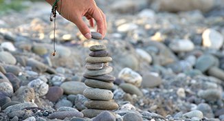 Image of A person stacking pebbles